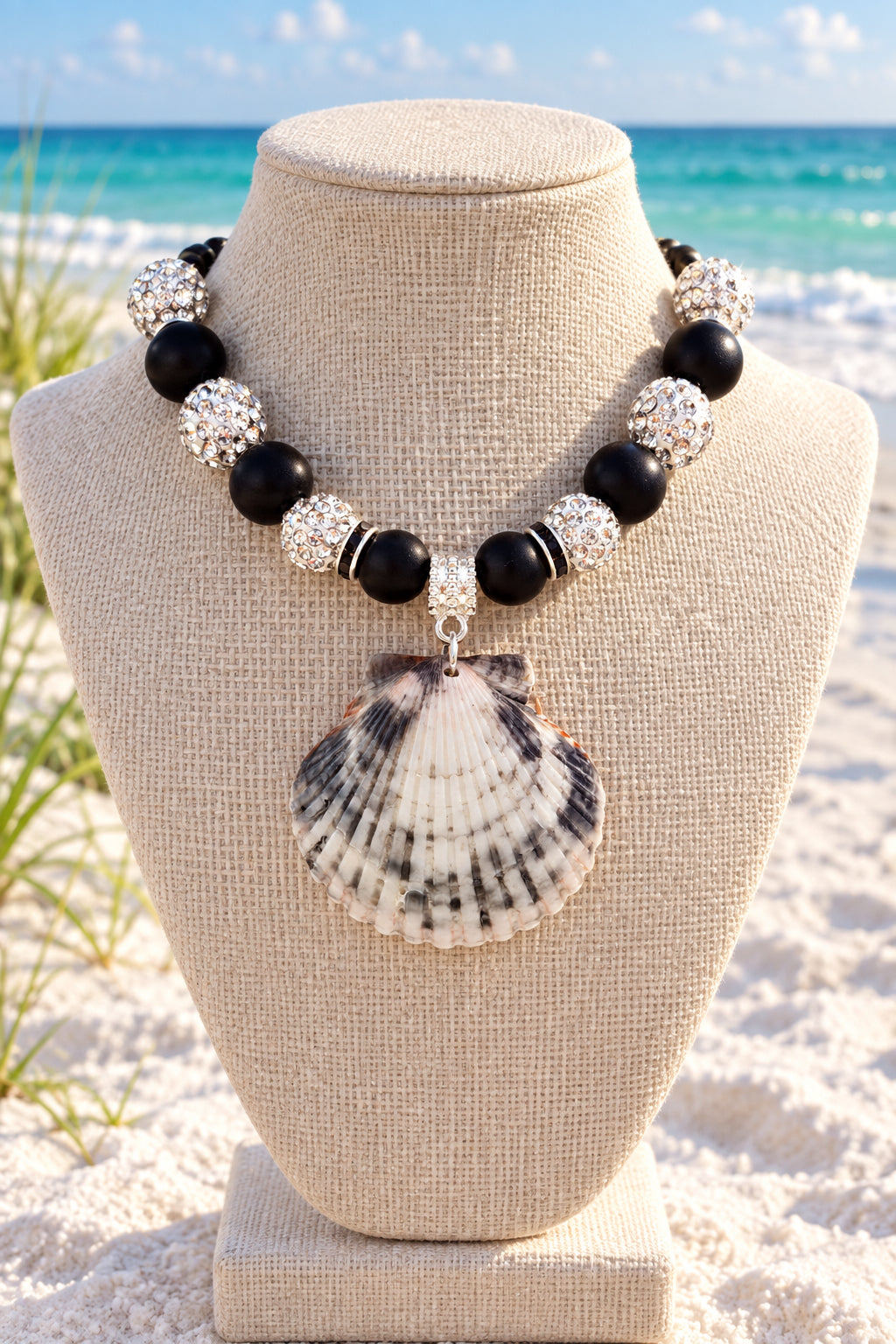 Close-up of coordinating black bow bracelet and shell earrings