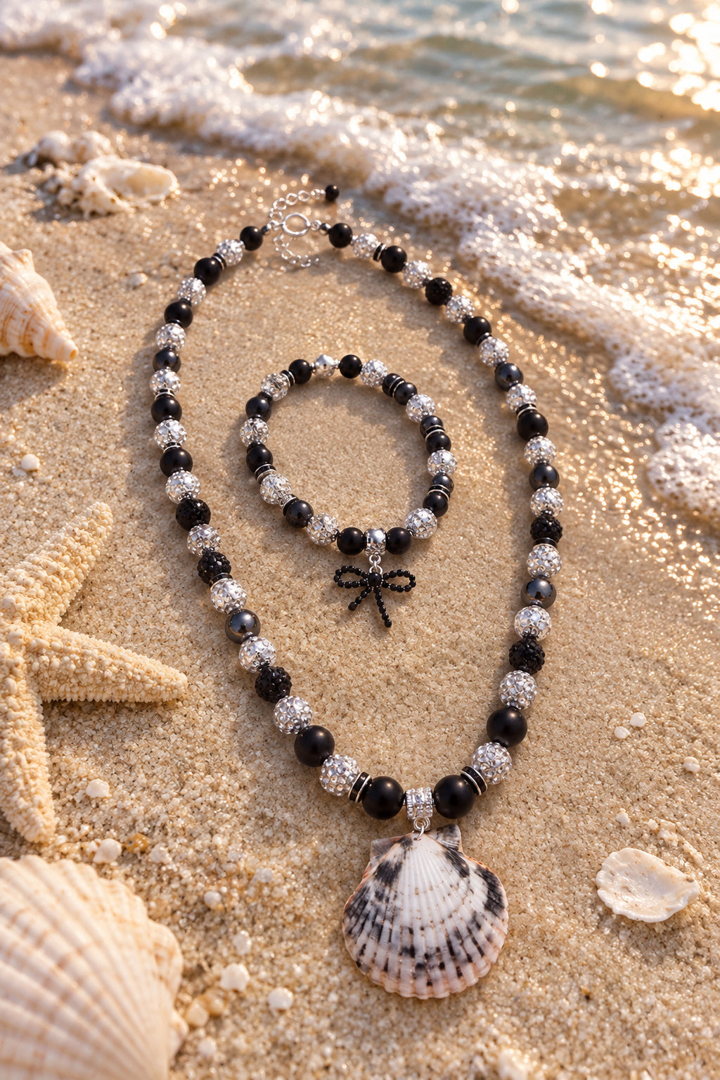 Matching drop earrings with black beads, pale shells, and black bow charms