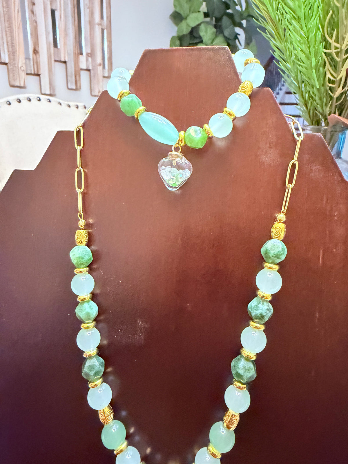 Coordinating green beaded bracelet with heart charm and necklace details
