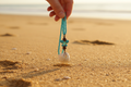 Necklace Being Picked Up on Beach - View 2
