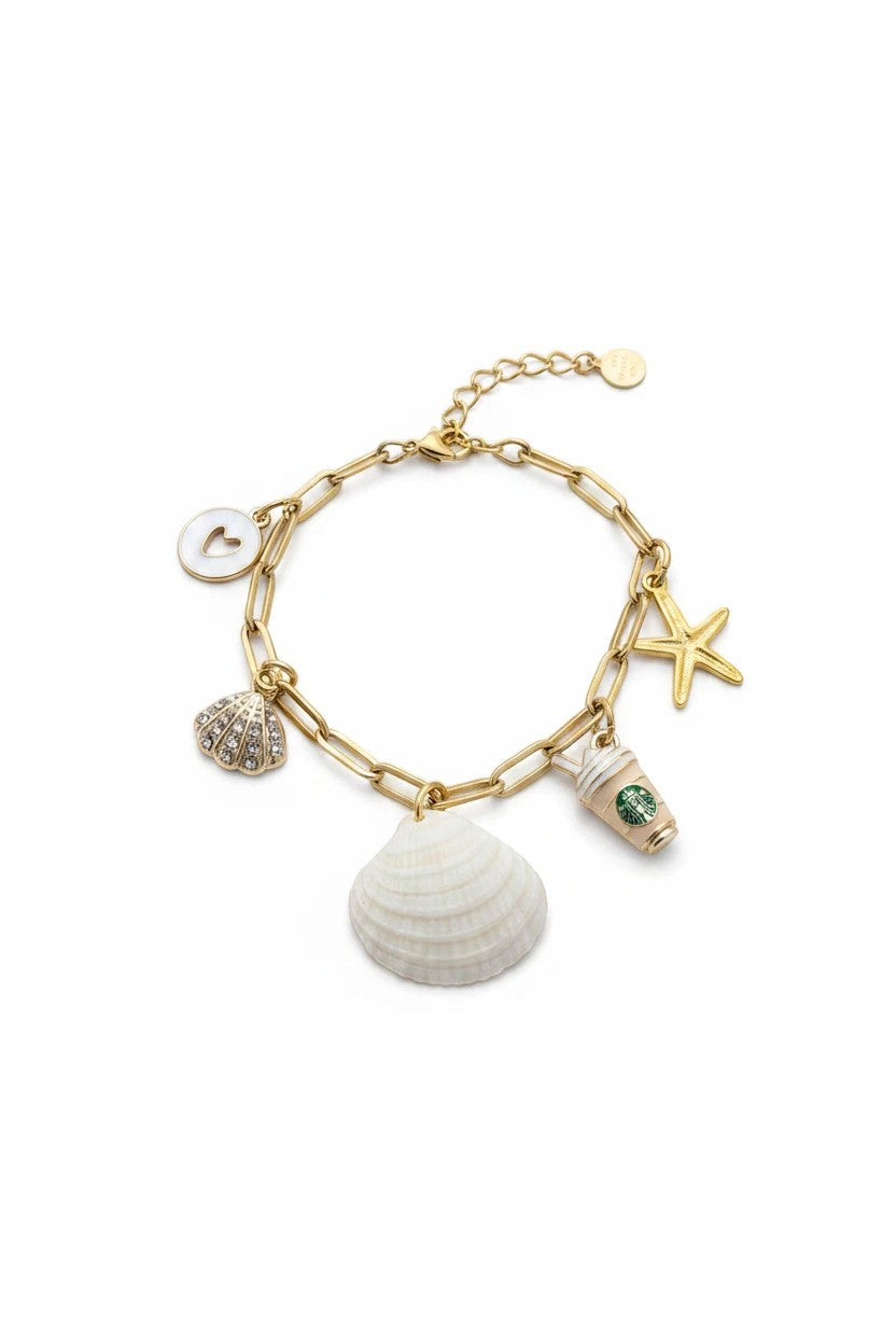 Shoreline Keepsakes gold paperclip charm bracelet featuring a natural ribbed venus clam shell and coastal charms.