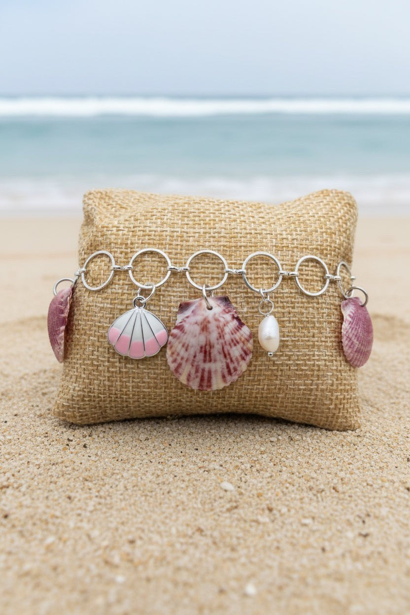 Shoreline Keepsakes shell charm bracelet with calico scallop shells, freshwater pearls, and seahorse on silver chain.