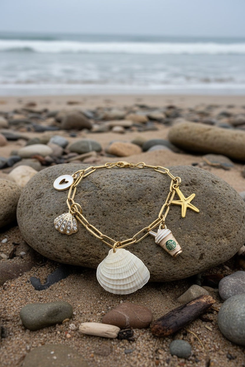 Shoreline Keepsakes gold paperclip charm bracelet featuring a genuine ribbed venus clam shell, starfish, and coffee cup.