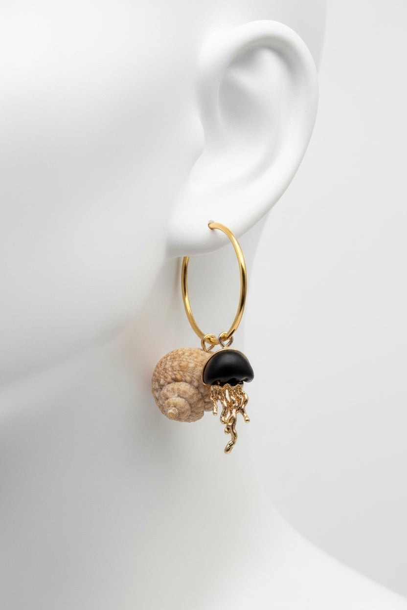 Shoreline Keepsakes gold hoop earrings featuring a natural turban shell, matte black bead, and gold jellyfish charm.